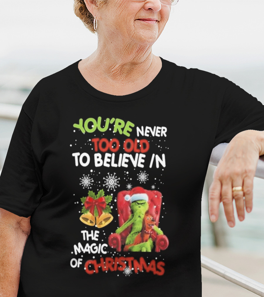 YOU'RE NEVER TOO OLD TO BELIEVE IN THE MAGIC OF CHRISTMAS GRINCH WITH MAX SITTING IN CHAIR SNOWFLAKES HOLIDAY BELLS AND BOW T-Shirt