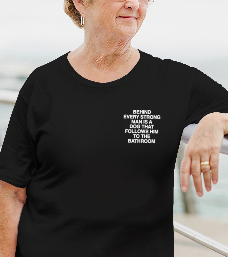 BEHIND EVERY STRONG MAN IS A DOG THAT FOLLOWS HIM TO THE BATHROOM T-Shirt